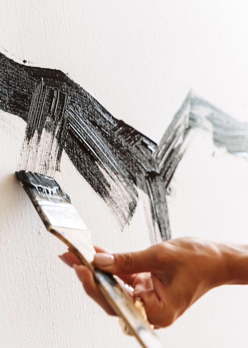 portrait-of-young-woman-using-painting-tools-while-9XNT4GZ.jpg